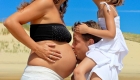 un pere donne un bisous sur le ventre de sa femme enceinte