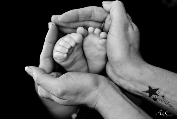 pieds de bebe entourés des mains de maman
