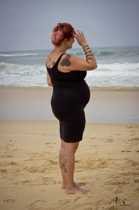 femme enceinte tatouée à la plage