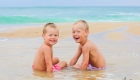 deux frères jouent dans l'eau à la plage
