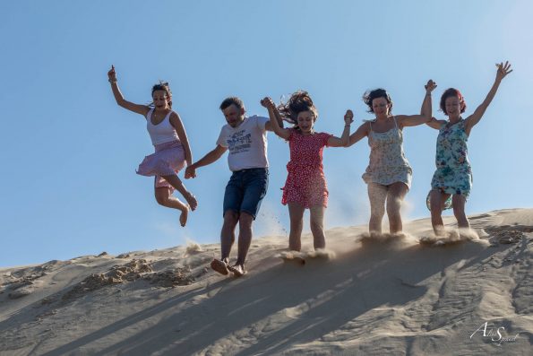 Famille saute dans le sable