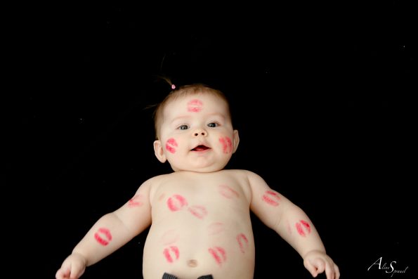 un bebe remplit de bisous en rouges à lèvres