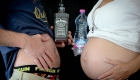 un ventre de grossesse contre contre un ventre de whisky