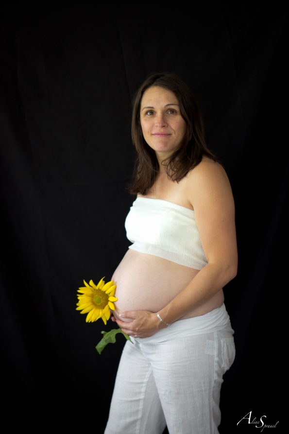 femme enceinte tient un tournesol