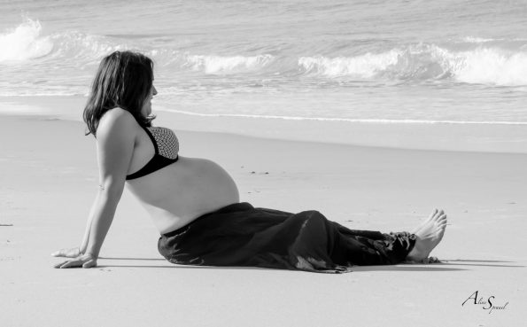 femme enceinte assise sur le sable